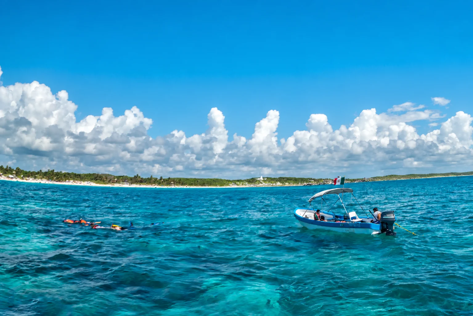 Schnorchler und ein Boot auf dem Karibischen Meer bei Tulum